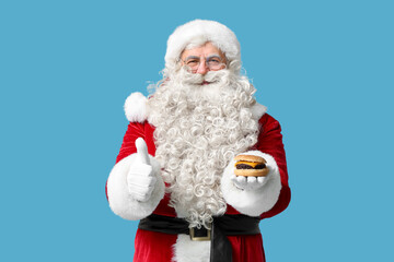 Santa Claus with tasty burger showing thumb-up on blue  background