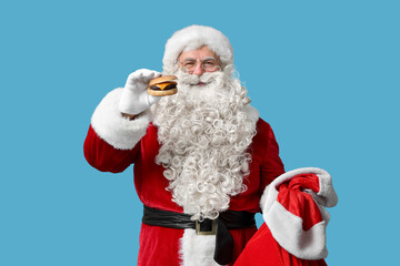 Santa Claus with tasty burger  on blue background