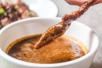 close up of chicken satay dipped in peanut sauce. Indonesian food.