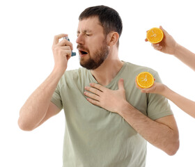 Young man using asthma inhaler and female hands with orange on white background. Food Allergy...