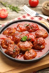 Delicious meatballs with tomato sauce in baking dish on table, closeup