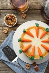 Delicious homemade carrot cake served on wooden table, flat lay