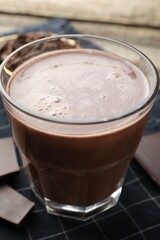 Tasty chocolate milk on wooden table, closeup