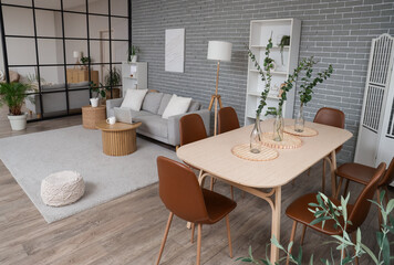Interior of studio apartment with folding screen, sofa and dining table