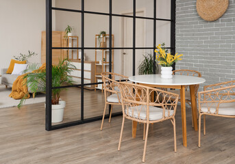 Interior of studio apartment with folding screen, dining table and sofa