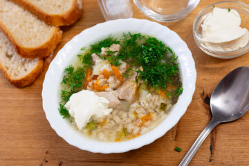 Tasty soup rassolnik served in bowl on table, decorated with parsley sprig. Traditional russian dish