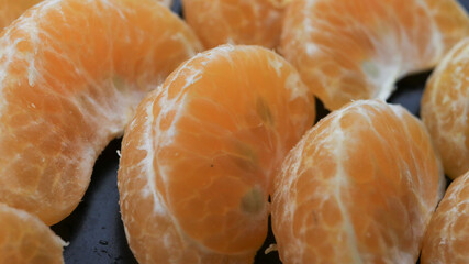 From a close up of the photo of neatly lined orange oranges with black tools, the photo shot is seen from the side