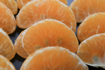 From a close-up photo, neatly arranged orange oranges with black tools.