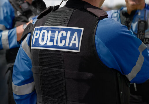 Polic&iacute;a - Marca POLICIA en la parte posterior de un chaleco antipu&ntilde;alamiento de alta visibilidad usado por oficiales de polic&iacute;a local y polic&iacute;a nacional en la escena de un incidente.