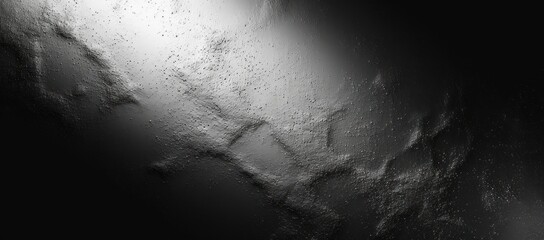dark textured surface with rough uneven patches illuminated partially by soft light creating a mysterious and moody atmosphere