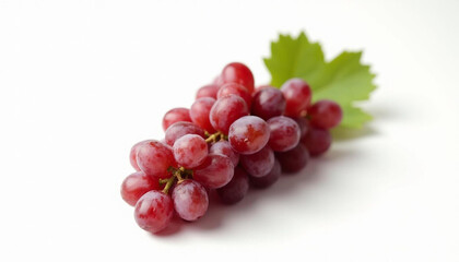 Fototapeta premium A beautiful bunch of delicious red grapes, with a leaf on a white surface, perfect for eating.