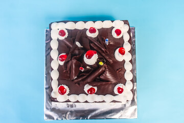 chocolate birthday cake with candles on blue background