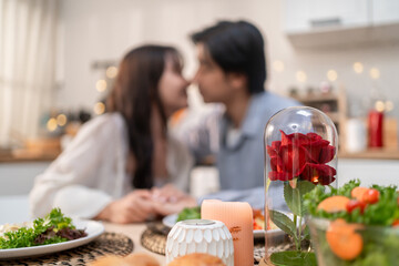 Asian young loving couple kissing each other in kitchen room at home.