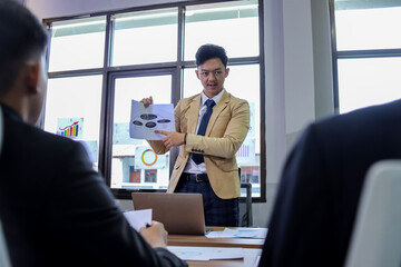 Business executive discussing project management with staff in an office team meeting focused on strategic planning.