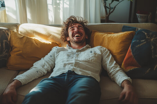 Man laughing on a couch surrounded by friends and family. Joyful atmosphere with bright colors and cozy decor in a living room setting.