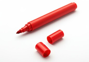 A red marker with two caps lying beside it on a white surface in a studio setting image view