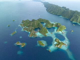 A set of beautiful rock islands rise from the ocean in Misool, Raja Ampat, Indonesia. This area is known as the heart of marine biodiversity and is a popular destination for diving and snorkeling.