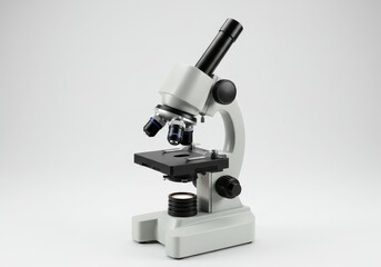 A microscope with a white body and black accents isolated on a plain white background in a studio