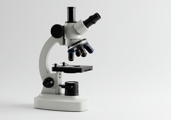 A white and black microscope sitting on a white surface in a well lit studio setting for science