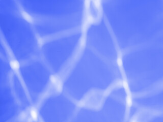 Light reflects on the water surface on the blue wall and blurs.