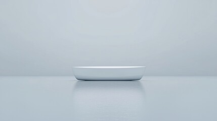 Minimalist photo of an empty white ceramic dish centered on a glossy, light blue surface with a soft, pale background.