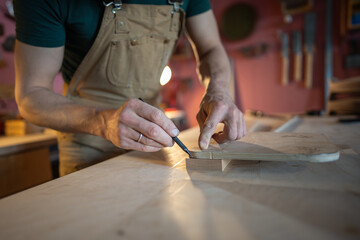 Unrecognizable carpenter hands marking precise angles and screw locations on wooden furniture component. Workshop measurement, assembly prepare, precision in pencil markings, woodworking craftsmanship