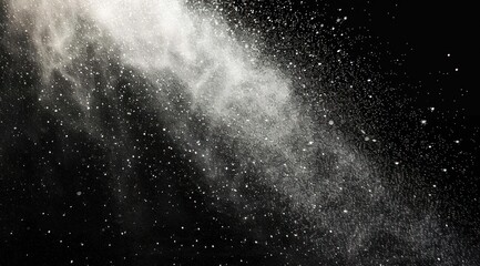 Close-up of fine white powder or dust particles dispersing and floating against a dark black background, creating a dynamic and textured visual effect