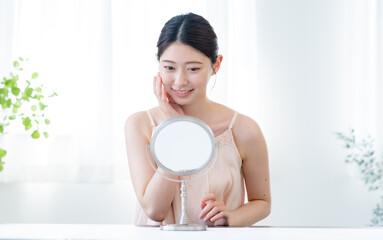 鏡を見て微笑む日本人女性