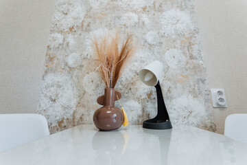 A beautifully arranged table showcases two elegantly designed vases alongside a stylish lamp,...