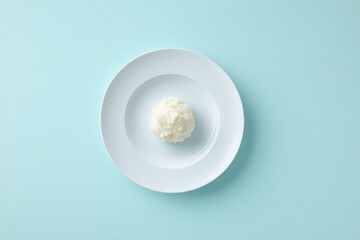 top-down view of single serving of mashed potatoes elegantly plated on clean solid color background