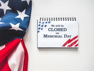 We will be closed on Memorial Day. American Flag and sign board with the inscription. Closeup, no people. Congratulations for family, relatives, friends, colleagues