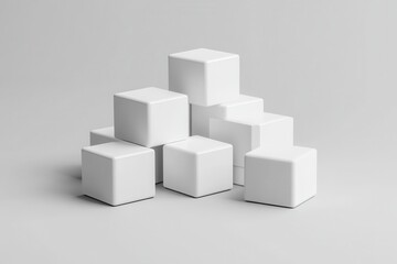 A minimalist arrangement of several white cubes stacked on top of each other on a gray surface