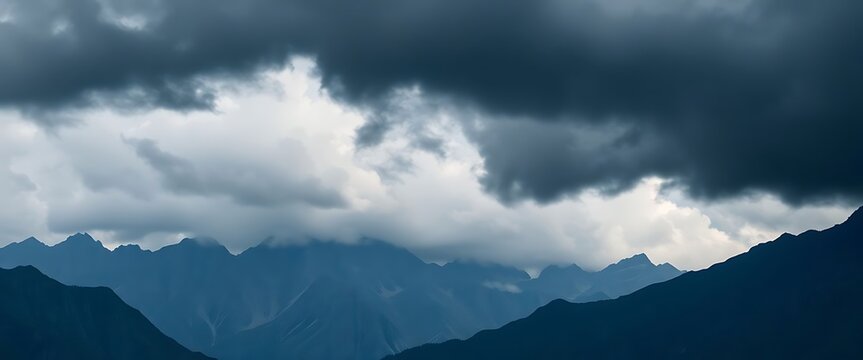 mountain range under a cloudy sky with dark clouds