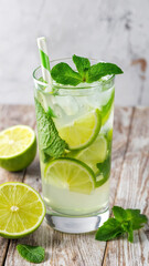 Virgin Mojito mocktail with lime slices, mint leaves, and a green straw. Bubbles are visible, set against a light gray background