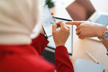 Two colleagues are collaborating on a project. They are using a tablet and stylus to review data, likely to improve efficiency.