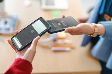 Two people are using their phones to make a contactless payment. They are doing this because it is a fast and secure way to transfer money.