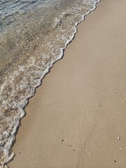 Gentle Wave Washing Up on Sandy Beach Shore