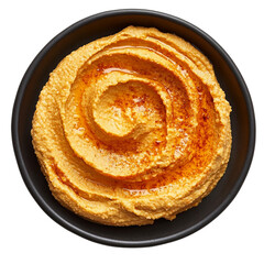 Fototapeta premium Creamy orange hummus presented in a circular swirl on a black plate [Transparent Background PNG]. 