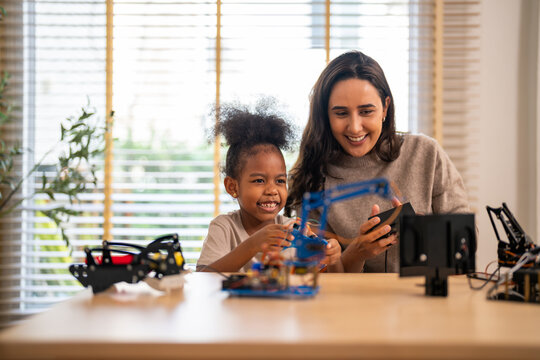 Portrait happy teacher help school children student having fun activity learn training play building toy STEM, education, science, engineering, programming, coding, robot technology class at school - Powered by Adobe