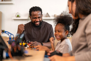 African love family, father mother and daughter learning STEM education, science experiment, robotics toy, technology and innovation interactive learning, creativity and development at home