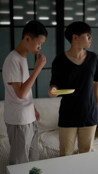 Brother sitting and eating snacks at home.