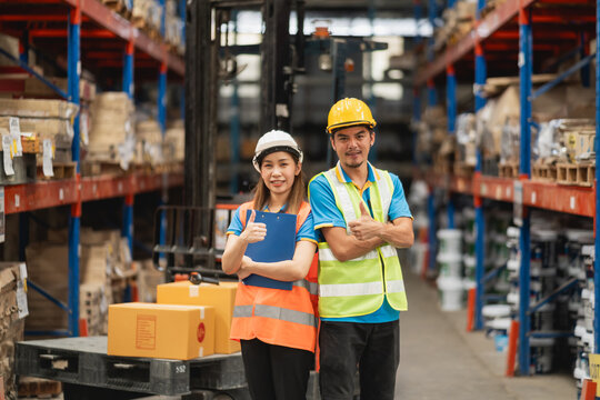 Professional warehouse workers standing confidently in storage facility, showcasing teamwork and safety in industrial environment