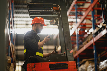 Warehouse Worker Operating Forklift with Safety Helmet in Industrial Storage Environment