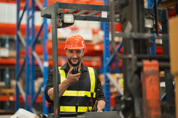 Warehouse Worker with Communication Device on Forklift in Busy Storage Facility