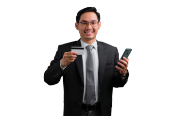 Happy young Asian businessman holding credit card and smartphone, making payment online, isolated on transparent background