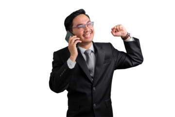 Happy young Asian businessman celebrating success while talking on the phone, fist raised, smiling and excited, isolated on transparent background
