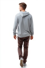 Naklejka premium A man wearing a gray hoodie and brown pants walks on a white background. The image conveys a casual and relaxed atmosphere, as the man is walking leisurely and enjoying his surroundings