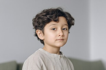 portrait of child looking directly at camera with serene expression blurred background for effect