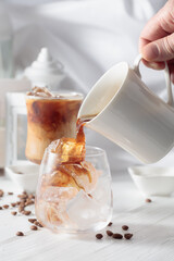 Black coffee is poured into a glass with iced.