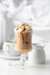 Iced caramel latte topped with whipped cream and caramel sauce.